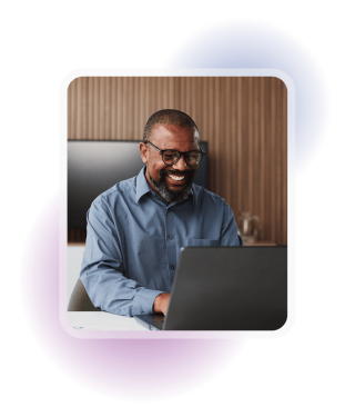 Employee smiling while working on a laptop, representing a streamlined digital background screening process