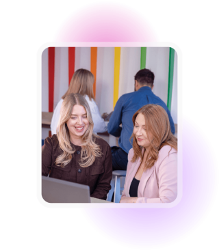 Two women smiling and looking at a computer