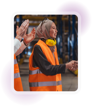 Employee wearing high-visibility safety clothing greeting a colleague in a workplace
