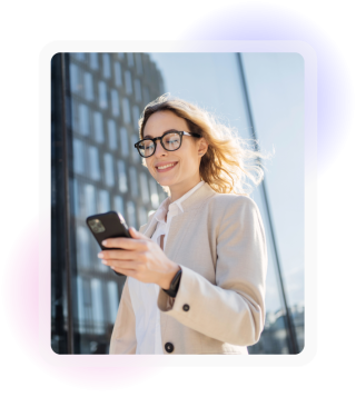 A woman in smart clothing looking at a mobile phone and smiling