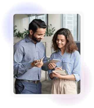 Two colleagues reviewing information together on a tablet in an office