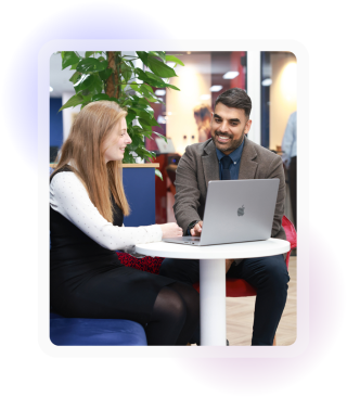 Two colleagues, one male, one female sat looking at laptop screen