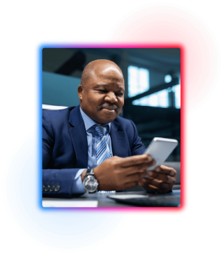 Business man in suit and tie sat at desk looking at phone