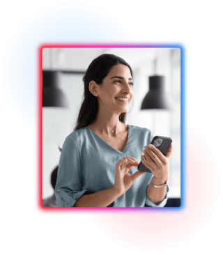 Young woman stood holding a mobile phone smiling