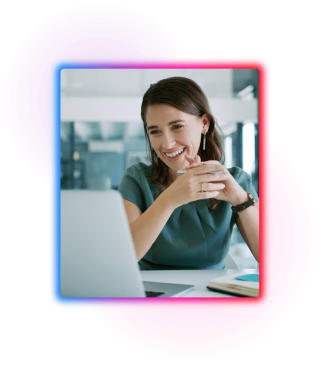 Business woman sat at a desk in an office looking at laptop screen