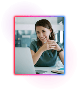 A female sat at a desk looking at a laptop