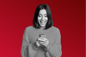 Women smiling at her phone after her HR, payroll and finance software streamlines her processes allowing her to save time and her business save money.