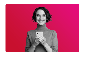 a lady smiling, holding her phone.