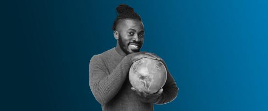 A man holding a globe smiling.