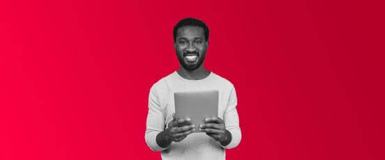 A man smiling holding an tablet in front of him