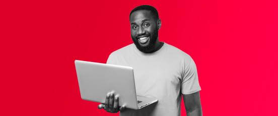 Man smiling at his screen after being accepted for flexible working under the new legislation was approved.