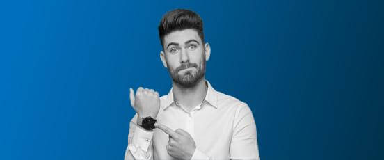 A man pointing to his watch. 