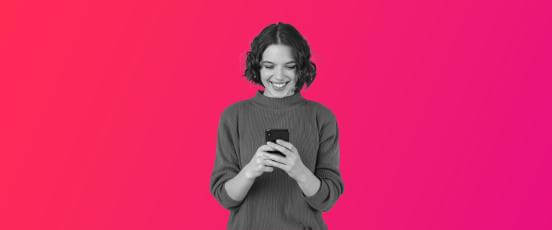 a lady smiling looking down at her phone, happy after implementing an effective PTO policy