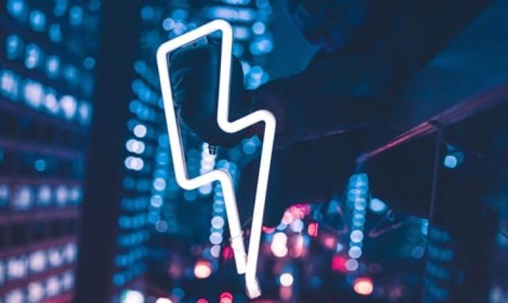 A neon lightning bolt, with blurred neon lights behind