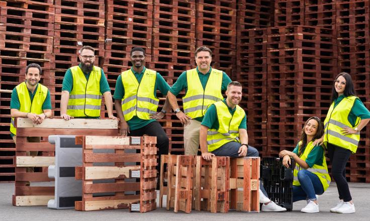 An image of IPP employees in hi viz surrounded by pallets. 
