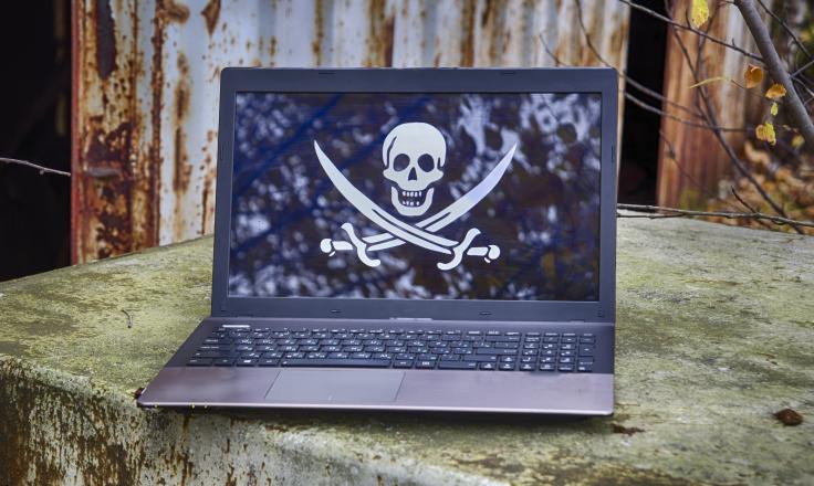 Skull and crossbones pictured on a laptop, representing data piracy