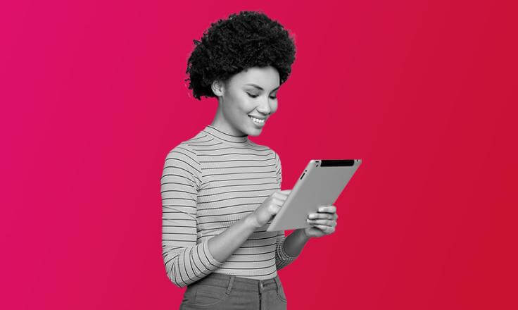a lady on her ipad smiling, happy after introducing new learning and development strategies.