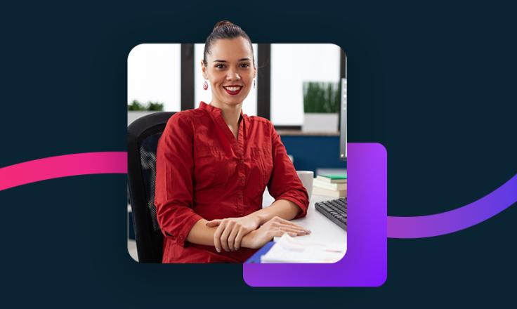 Woman in a red shirt sitting at her desk.