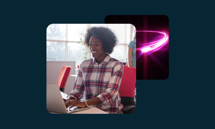 A lady working on a laptop smiling.