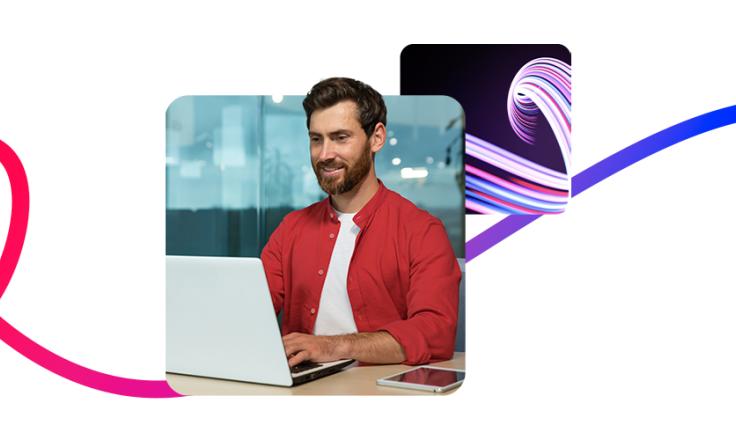 A man sat at a desk working on a laptop.