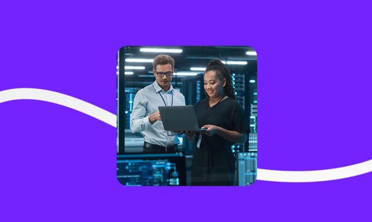 Image of two employees at a computer against a purple background