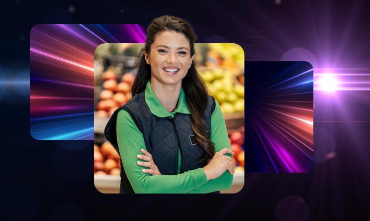 A retail worker in a green uniform, smiling with folded arms.