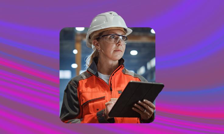 Female construction worker wearing a safety helmet and holding a clipboard