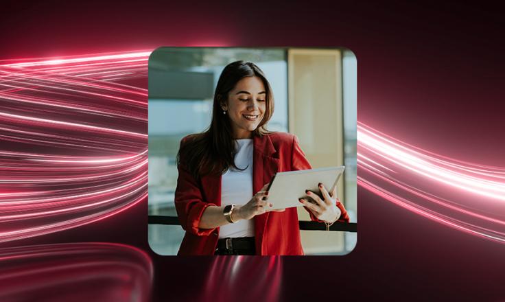 A small business manager smiling at a handheld tablet.