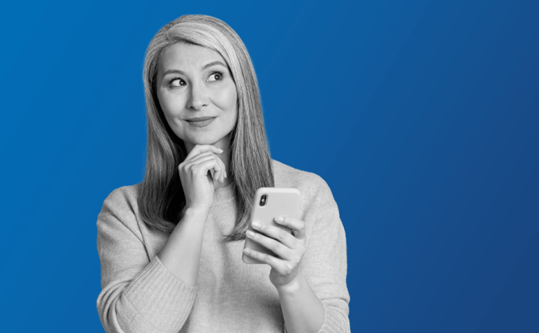 Woman smiling at her phone, realising she has financial wellbeing freedom.