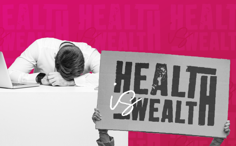 Man with head down on his desk with sign saying health is wealth