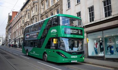 Green Nottingham City Transport bus driving down a street