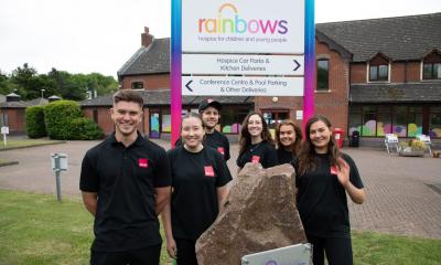 MHR volunteers standing in front of Rainbows hospice sign