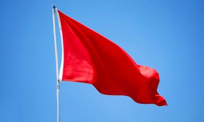 Red flag waving in the wind, representing red flags or 'icks' in the office