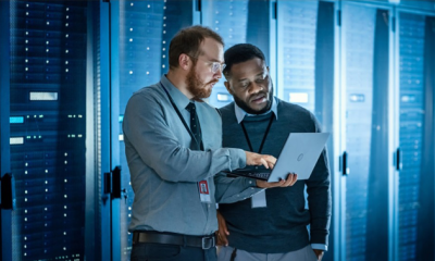 two men wearing corporate wear looking at laptop with coding for it and cloud services at MHR