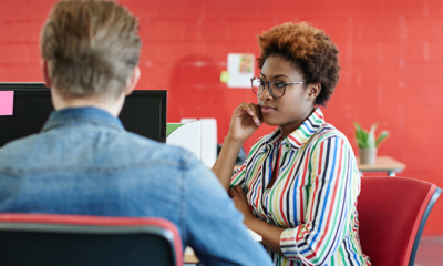 a man and a lady sat discussing HR software from People First.