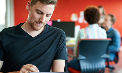 a man sat on a tablet accessing real-time payroll through people first.