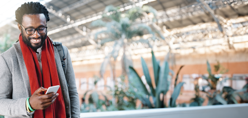 happy man with red scarf looking at People First, HR and payroll solution on his phone