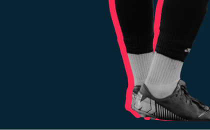 Football boot about to kick a football.