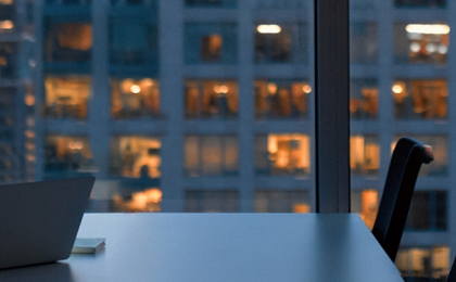 A lady working in a skyscraper, on a laptop. using MHR's finance integration to do financial planning.