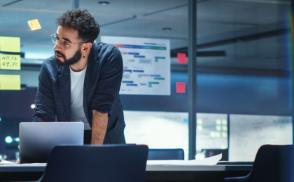 Two outsourced payroll professionals looking at a laptop