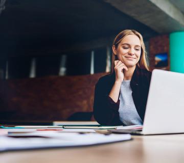 Woman Smiling at Laptop