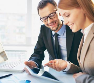 Man and woman working on laptop and tablet