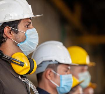 Construction workers in safety hats and masks