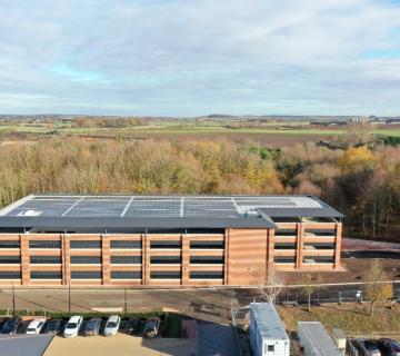 Multi-storey carpark viewed from the sky with landscape behind