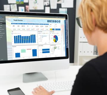 Woman looking at monitor with People Analytics showing