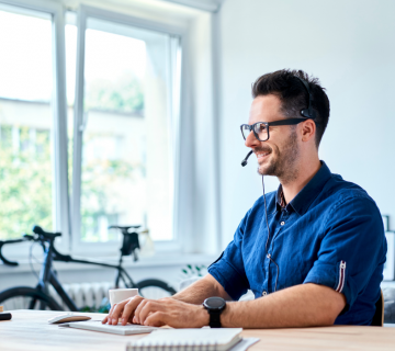 A man working alone from a home setting on a laptop at a desk