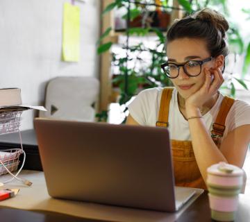 Woman sat at desk with laptop working remotely