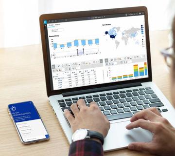 Computer and phone screen with IBM Planning Analytics charts and data presented