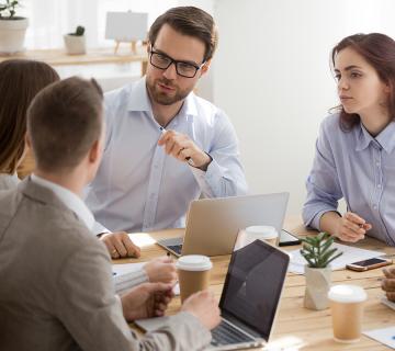 Group of people in a room speaking over coffee