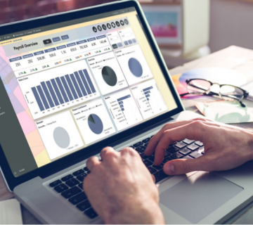 laptop with hands on showing payroll dashboard